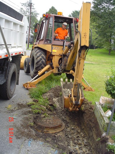 A highway maintenance worker uses heavy equipment to work on the side of the road. 
