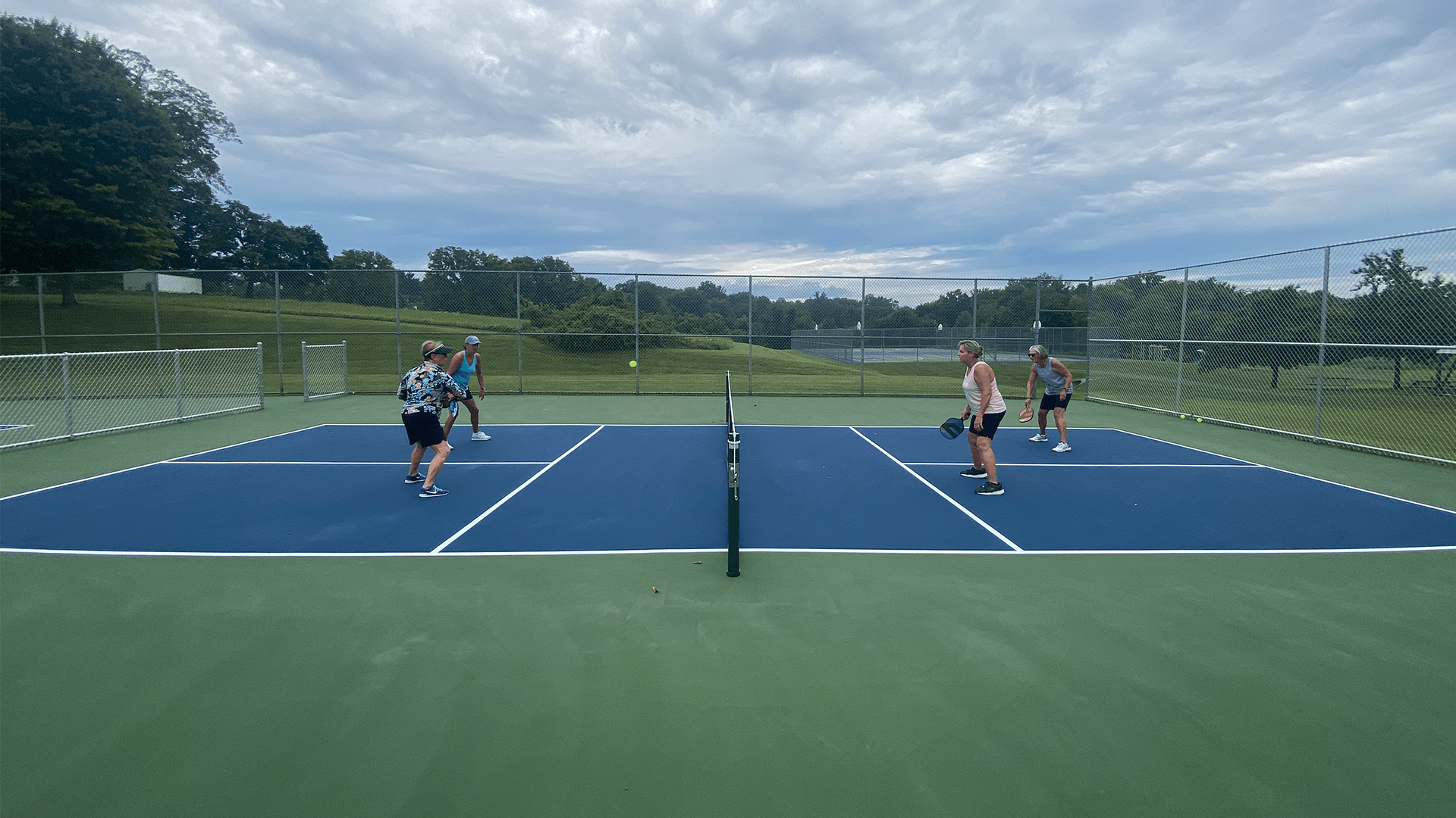 Four women playing pickleball